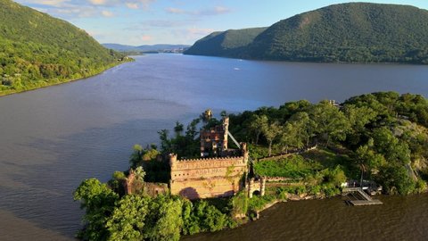 Aerial drone footage of an abandoned castle on a small island. This is Bannerman's castle on Pollepel island in New York's Hudson River Valley during summer in America.