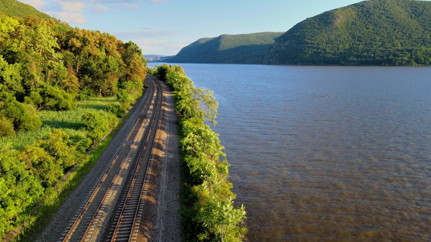 Aerial drone footage of the metro north Hudson Line train tracks during summer next to the Hudson river between beacon and cold spring, new york, usa Royalty-Free Stock Footage #1077155513