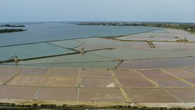 Aerial shooting with drone of the salt flats of the Lagoon of Stagnone and Mozia, between Trapani and Marsala. Salt water color, sometimes pink with the white of the salt and the blue of the sea.