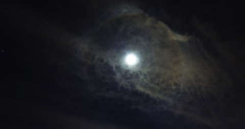 Lunar halo or moon halo, partially encircles the rising moon with high-altitude cirrostratus clouds and pin point star