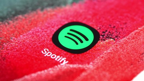 Thailand - Aug, 2021: On demand music and online media streaming concept. Slow motion finger pressing spotify application icon on modern 5G smartphone.