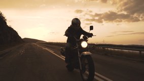 Silhouette of Biker riding vintage motorcycle on country road at sunset - Powered by Shutterstock - Get 15% off with code: PIKWIZARD15