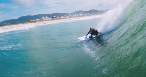 FLORIANOPOLIS, BRAZIL - MARCH, 2021: Surfer rides ocean wave at Campeche beach in Brazil