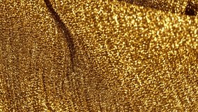 4K video footage of smooth waves of soft elegant golden sparkling fabric (textile). Abstract Christmas shiny video background
