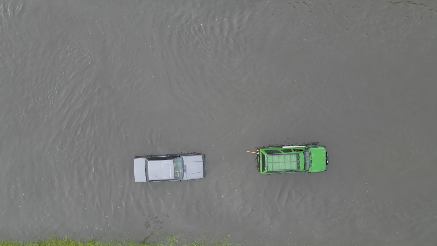Aerial view of city traffic with cars driving on flooded street after heavy rain. Problems with road drainage system. | Shutterstock HD Video #1077171269