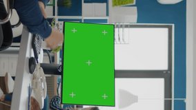 Video vertical: Handicapped paralysed invalid entretreneur with face mask explaning to black employee financial evolution of company pointing at green screen, mock up, chroma key izolated desktop in