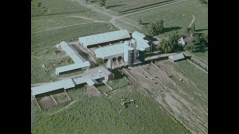 1970s: Aerial views. A baseball stadium. Tower on a hill. Man in cockpit turns the helicopter. Aerial view of a dairy farm. Horizon gauge tilts. Flying over a highway. Underside of a helicopter.