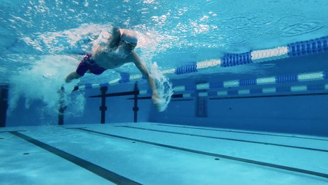 Concept of sports activity, determination, workout, healthy lifestyle. Professional swimmer practicing swimming underwater