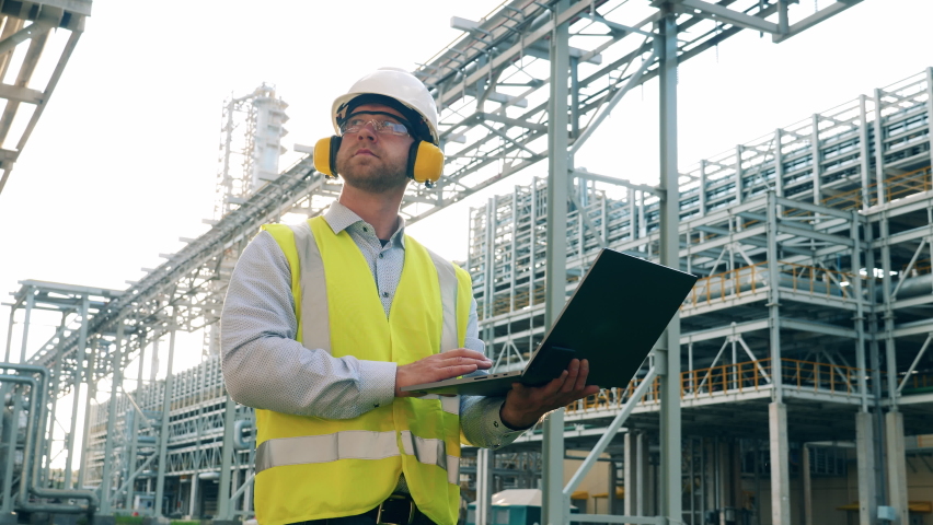 Refinery worker with a laptop on the plant premises Royalty-Free Stock Footage #1077181874