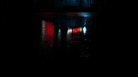 Red white advertising signs reflect on wet road during drizzling rain at night. Raindrops hit the puddle with shimmering city light - Powered by Shutterstock - Get 15% off with code: PIKWIZARD15