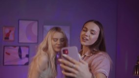 Happy young women teenagers vloggers using phone dancing, speaking at camera webcam, video chat with online, selfie video call, talking record lifestyle vlog, young blogger online streaming
