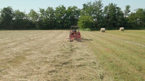 Farmer Works On Tractor Making Hay For Harvesting During Summer In Italy. - Tracking Shot