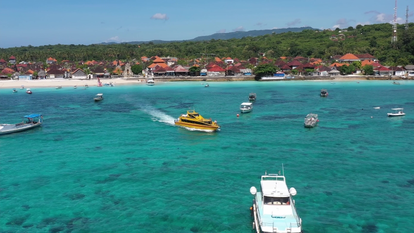 Aerial drone footage of a speed boat ferry leaving the Nusa Lembongan island for Sanur in Bali, Indonesia Royalty-Free Stock Footage #1077204698