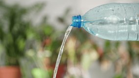pure drinking water is poured into a glass from an ecological plastic bottle at the plant office, close-up - Powered by Shutterstock - Get 15% off with code: PIKWIZARD15