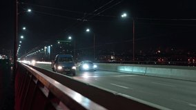 Fast traffic on a bridge with cold light across the dnieper river in the big night bright city of Dnepropetrovsk in wonderful Ukraine. UHD 4K realtime video