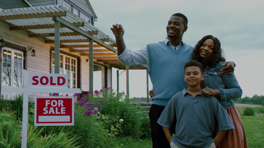 Portrait of happy African American Black family posing near sold sign, their new house in the background. Shot with 2x anamorphic lens Royalty-Free Stock Footage #1077221837