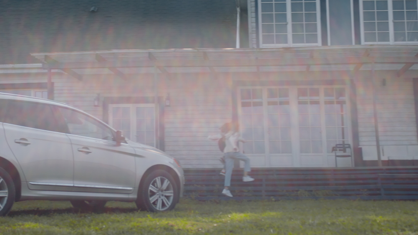 TRACKING Happy Caucasian family of four arriving by car to an American countryside house. Shot with 2x anamorphic lens