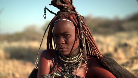 Beautiful young Himba woman wearing traditional jewelry and headpiece at her village near Kamanjab in northern Namibia, Africa. 