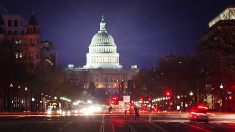 US Capitol at night time-lapse with light flares and traffic moving. USA Government