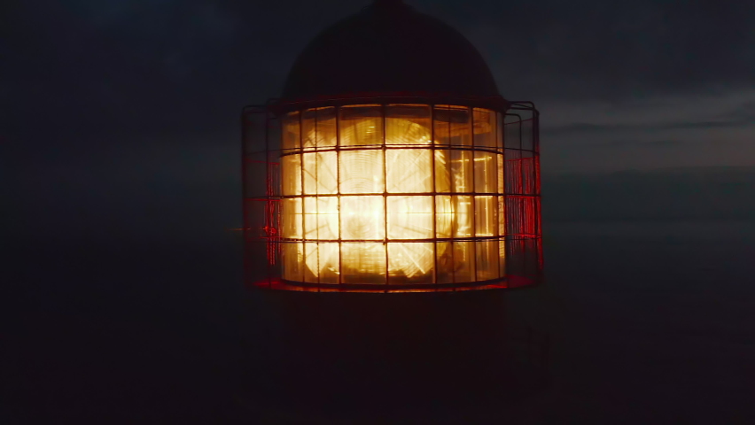 Close up of lighthouse shining head fresnel lens at dusk, drone circling around reveals sensational evening sea panorama, Lagos, Portugal Royalty-Free Stock Footage #1077228965