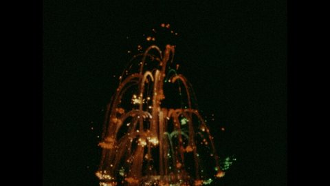 1970s: City street at night. View of light display. Neon light rotating. Close up of disco ball, zoom out. Colored light beams, end title.