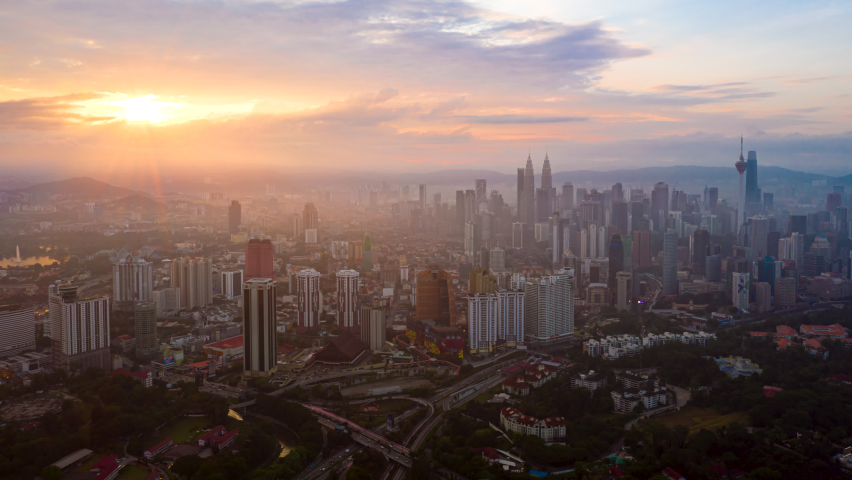 Cityscape Time lapse : Wide angle aerial Kuala Lumpur city view from during sunrise overlooking the KL city skyline with beautiful ray of lights in Malaysia. Pan up motion time lapse. Royalty-Free Stock Footage #1077238958