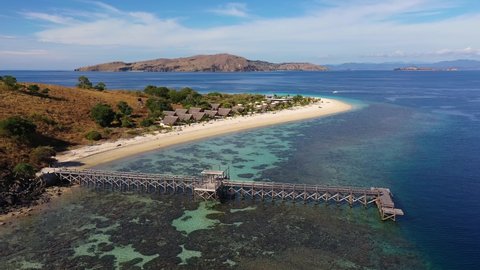Aerial drone footage of an idyllic island off the coast of Flores in Labuan Bajo, Indonesia. Shot with a upward and tilt down motion. 
