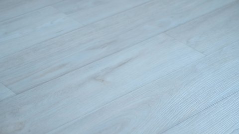 Light grey linoleum surface on floor with wooden pattern, wood texture. Looks like laminate. Modern material for renovation.