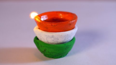 Tricolor Diyas burning brightly on the occasion of Independence day celebrations. Burning oil lamp on a white table - Republic day celebrations