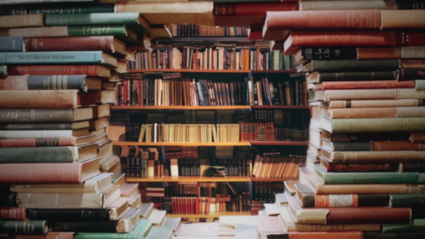 Library Stack of Books Zooming Through Bookshelves. Zoom In through some stack of books inside a big library. Background Royalty-Free Stock Footage #1077264953