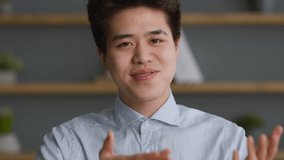 Online communication. Webcam pov portrait of young confiden asian man talking to camera, conversating with coworkers or recording video blog, slow motion