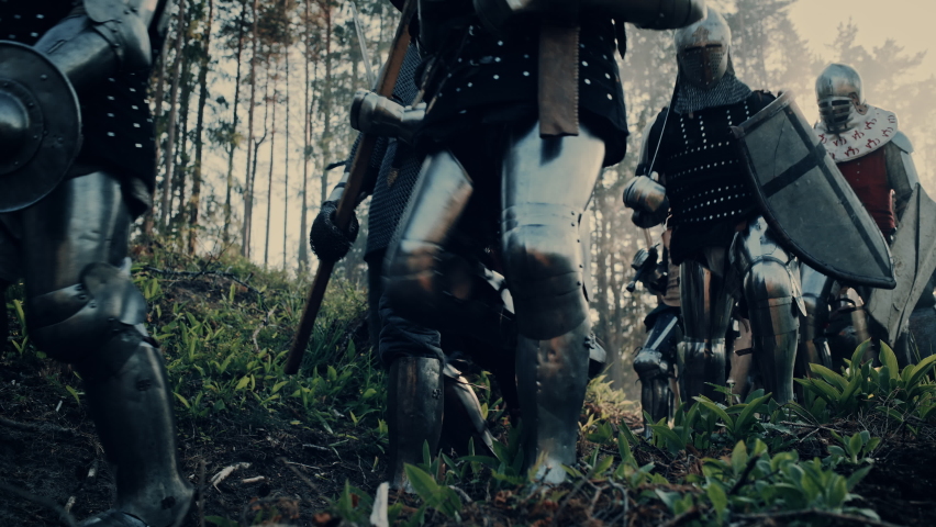 Epic Invading Army of Medieval Soldiers Marching Through Forest. Armored Warriors with Swords Moving to Battlefield. War, Battle, Crusades in Dark Ages. Cinematic Historical Reenactment. Low Angle | Shutterstock HD Video #1077268091