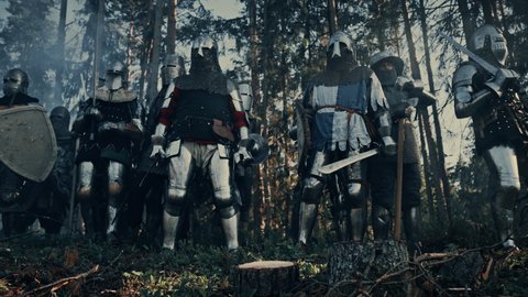 Epic Invading Army of Medieval Soldiers Marching on Battlefield, Armored Warriors with Swords, Getting Ready to Attack. War, Battle, Conquest. Historical Reenactment. Cinematic Low Angle Wide Shot