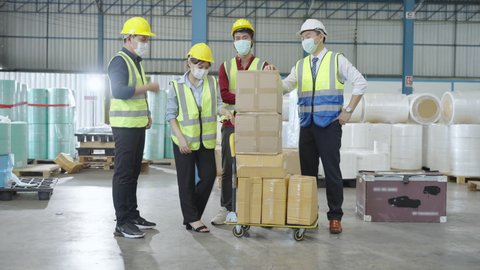 the workers wearing protective face mask and working in the warehouse during COVID-19 pandemic. the concept of coronavirus, shipping, logistics, business and transportation 