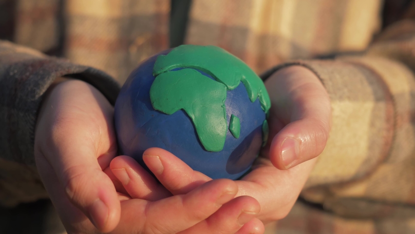 Hands holding colorful clay model of planet Earth outdoor. environment pollution, save clean planet and ecology, sustainable lifestyle. world earth day, creativity | Shutterstock HD Video #1077269606