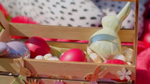 Close up of Easter eggs basket. Outdoor picnic. Children picking up the eggs. Spring holiday