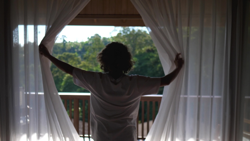 Back view of woman opening curtains and goes on a balcony. New day concept | Shutterstock HD Video #1077272276