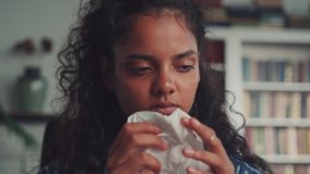 Allergic Indian woman blowing nose in tissue sit on sofa at home office study work on laptop, ill sick Hindu girl got flu caught cold sneeze in tissue having allergy symptoms coughing holding napkin. - Powered by Shutterstock - Get 15% off with code: PIKWIZARD15