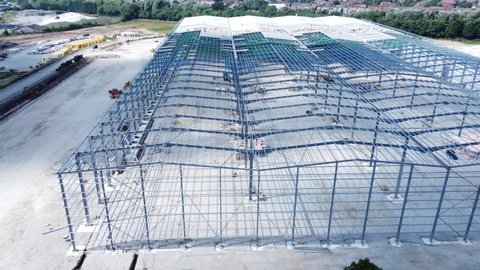 Construction industry metal iron girder warehouse framework construction site aerial view slow dolly right shot