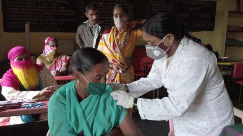 KOLHAPUR-INDIA - JULY 31, 2021: A medical worker inoculates woman with a Covid-19 coronavirus vaccine at village in Kolhapur.