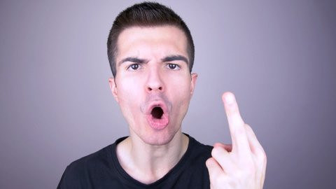 Furious young man shows with his finger the sign of fuck you