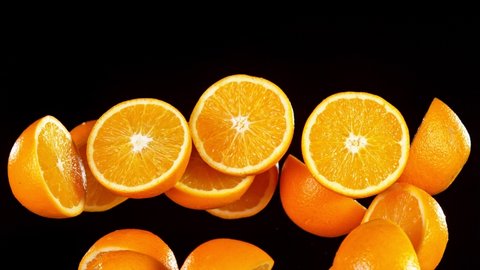 Super Slow Motion Shot of Flying Fresh Orange Cuts Isolated on Black at 1000 fps.