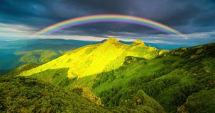 The rainbow is incredibly beautiful, bright and colorful at sunset in the Carpathians, the rapid movement of clouds using the time-lapse technique video