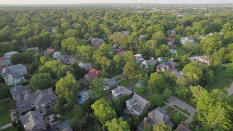 Push forward and tilt down over beautiful Clayton neighborhood in St. Louis, Missouri on a pretty summer evening.