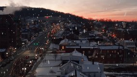 Snow falling at sunrise. Aerial truck shot of ski resort town covered in winter snow at sunset. Lights and Christmas holiday decorations. - Powered by Shutterstock - Get 15% off with code: PIKWIZARD15