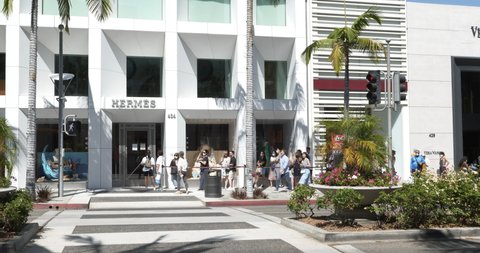 Beverly Hills, CA USA - Aug 1 2021: Line of customers wearing face masks in front of the Hermes store on Rodeo Drive