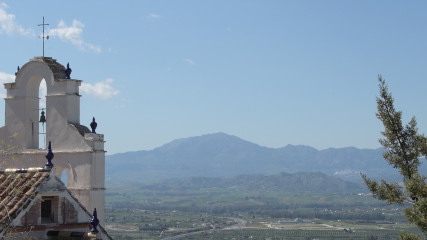 Bell tower of a ancient hermitage looking to the mountains at sunset, Cartama, Spain