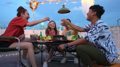 Group of Asian people friends having dinner party Korean barbecue grill and drinking alcohol vodka at outdoor rooftop. Man and woman enjoy and fun celebrating holiday event meeting reunion on vacationの動画素材