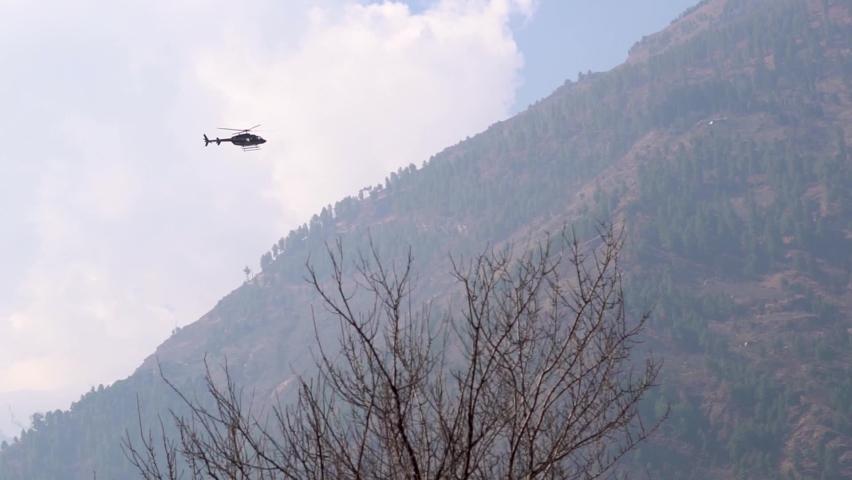 View of the Helicopter flying in front of the mountains at Manali in Himachal Pradesh, India | Shutterstock HD Video #1077326768