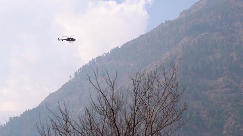 View of the Helicopter flying in front of the mountains at Manali in Himachal Pradesh, India